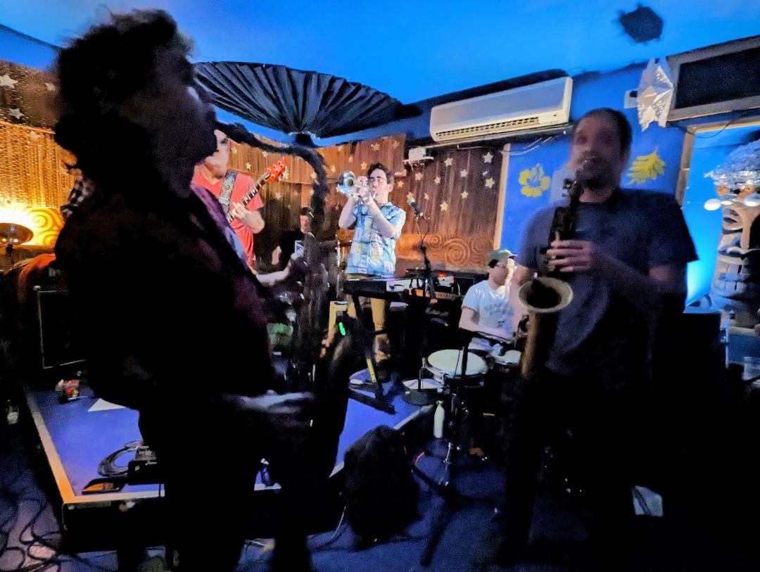 Photo of the Drop Party band at Subway2Skaville, 2 saxophone players front and center. 