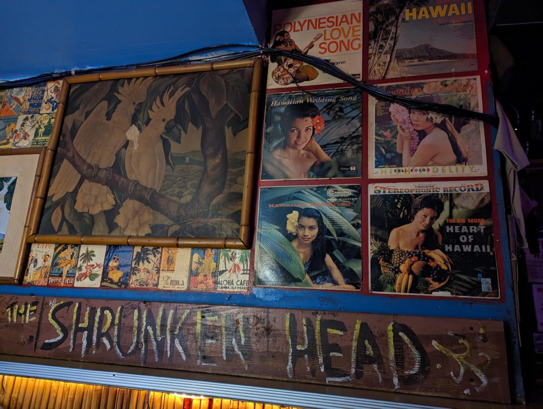 Tiki and Island style artwork on the wall of Otto's Shrunken Head Tiki Bar in NYC