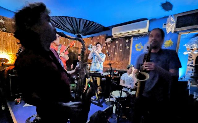 Photo of the Drop Party band at Subway2Skaville, 2 saxophone players front and center. 